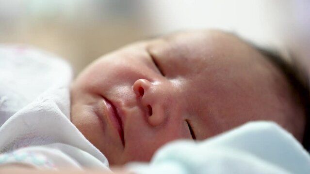 Newborn baby infant boy asian sleeping try to open eyes and peep and look Close up shot