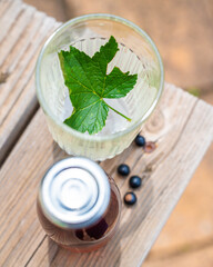 Une boisson avec une feuille de cassis dans le verre