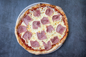 Homemade ham and cheese pizza on a rustic background. top view