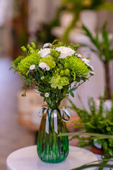 A bouquet of white roses standing in a vase on the floor