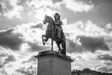 Equestrian statue of Louis XIV in front of the palace of Versailles near Paris, France. Black and white image.