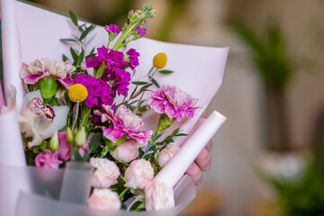 A close photo of a bouquet with purple and pink flowers. Bouquet with carnations