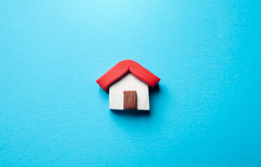 Fototapeta na wymiar Miniature house on a blue background. Buying and selling housing. Real estate market review. Construction industry. Design and architectural services. Property insurance.