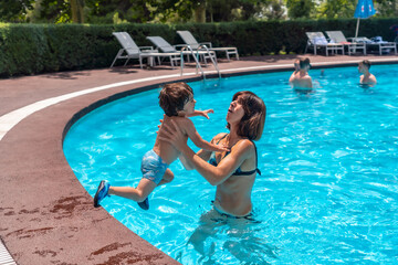 Mother and son in the pool on summer vacation, exciting vacation moment