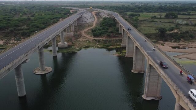Highway bridge built over the river basin in the Indian rural terrain, slow motion Drone shot