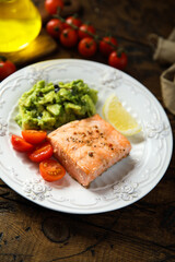 Healthy baked salmon fillet with mashed avocado