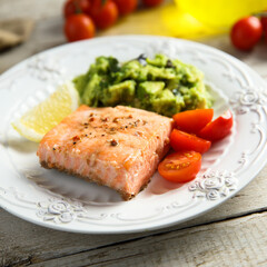 Healthy baked salmon fillet with mashed avocado