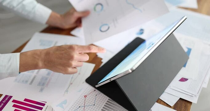 Businesswoman analyzing charts on digital tablet and paper documents closeup 4k movie slow motion. Business profit growth concept