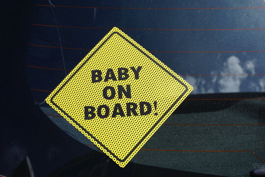 Baby On Board caution sign in rear window of family car. Safe driving 