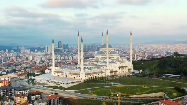Aerial drone view of Istanbul at sunset, Turkey. Camlica mosque with multiple buildings around, greenery, cityscape on the background