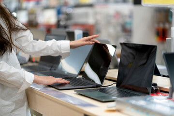 client in a retail shop choosing a new laptop for studying and working
