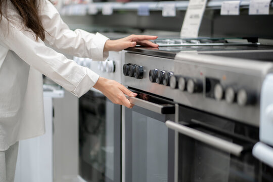 woman buying a new kitchen stove in the electronics retail store
