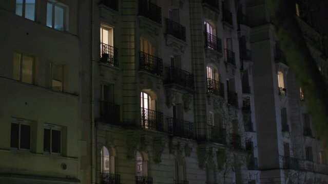 illuminated windows at apartment building in Paris at night