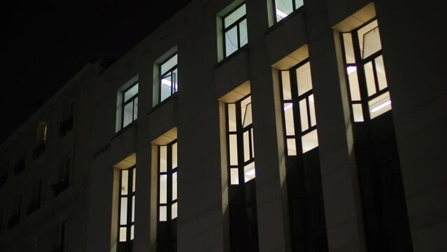 illuminated windows at apartment building in Paris at night