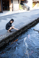 鯉に餌をあげる女性