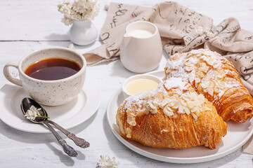Good morning concept. Breakfast with cup of coffee and fresh croissant. Sweet creamy sauce