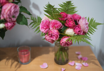 a bouquet of beautiful pink rose flowers with fern leaves in a vase