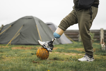 a man with a prosthetic leg is doing sports playing football
