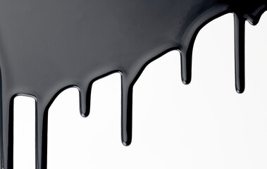Paint drops flowing down on white paper. Black ink blots abstract background