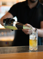 the bartender prepares a beautiful alcoholic cocktail at the bar counter