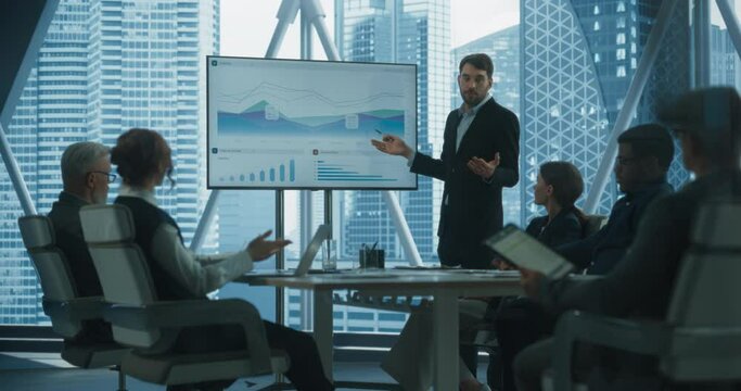 Diverse Skyscraper Office: Caucasian Businessman Hosting Business Meeting, Talks about Company Growth, Uses TV for Presentation. Entrepreneurs Work on Profit Margins Improvement. Dramtic Evening Edit.