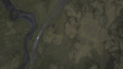Toyota SUV driving on a mountain road towards Snaefellsjoekull glacier and mountain peaks, drone shot, Snaefellsnes peninsula, Iceland, Europe