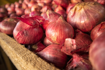 red onions in a wooden box in the market. Shallow depth of field