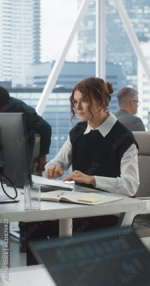 Poster Verstical Screen: Young Female Data Scientist Typing On Desktop Computer In Diverse Corporate Office With Megapolis Window View. Professional Caucasian Woman Working In Tech Startup With Colleagues.