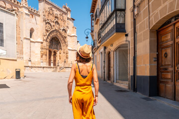 Woman visiting the church of Santa María la Real in Aranda de Duero in the province of Burgos. Spain - obrazy, fototapety, plakaty
