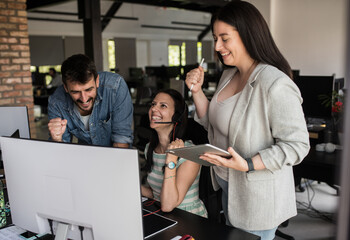 Coworkers celebrating successful IT project in office