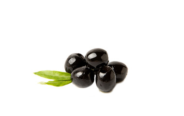 Tasty black olives isolated on white background. Olive and olive tree branches on a white table. Delicacy.