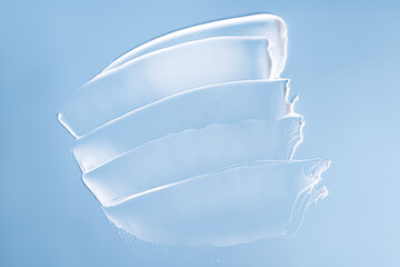 White smudges swatches smear of face or body care cream on a blue background. Pureness concept