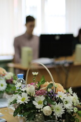 bouquet of flowers in a basket on the table diploma defense training students session
