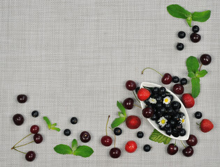 Naklejka na ściany i meble Fresh summer berries top view on linen tablecloth. Border with fresh summer berries and green mint leaves on light linen fabric background. Healthy summer dessert concept. Free copy space..