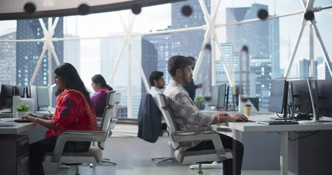 Team of Talented Young Indian Professionals Working in a Corporate Banking Agency. Financial Analysts and Managers Working on Computers in a South Asian Business Office with Scenic City View