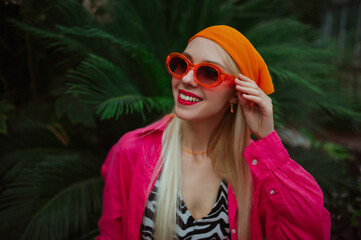Fashionable happy smiling woman wearing trendy orange sunglasses, bandana, pink fuchsia color linen...