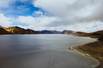 Pangong Lake transforms into a frozen wonderland in late March 2023. The icy surface reveals intricate cracks, adding a stunning texture to the landscape