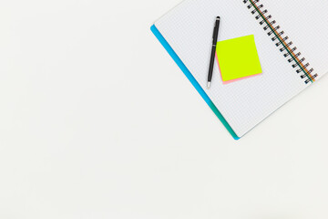 Notebook, pen and paper colored reminders on a white background.