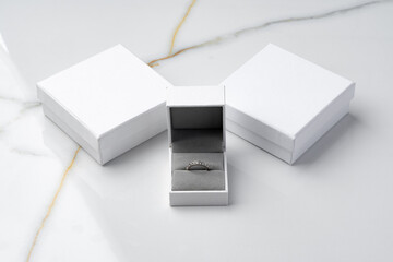 Golden ring in jewelry box on gray background