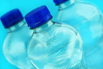 3 Flaschen Mineralwasser in der Nahaufnahme und blauer Hintergrund