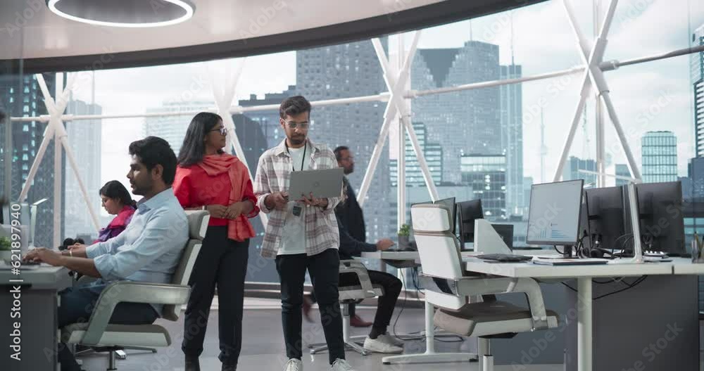 Poster Young Team of South Asian Specialists Working on Desktop Computers at a Modern Workplace. Indian Software Developer Discussing a Financial Software Project with a Female Team Leader