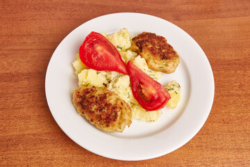 A dish of mashed potatoes, meat cutlets and tomatoes. Home cooking dishes.