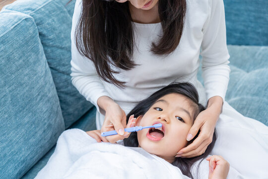 ママに歯磨きの仕上げ磨きをしてもら子供（育児・子育て・デンタルケア・健康）