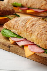 Chiabatta sandwich with ham and cheese on wooden board
