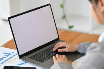 Behind shoulder view image of Young business woman with suit outfit working with laptop, Empty screen of laptop.