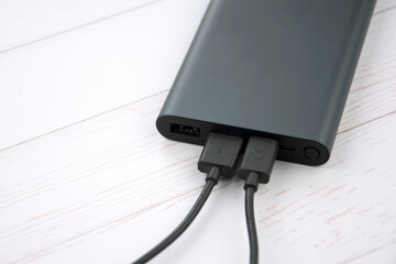 Power bank for charging mobile devices. Black smart phone charger with power bank.