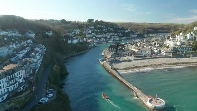 Aerial view of Looe, a small town with the harbour along the coastline in a small bay in Cornwall, United Kingdom.