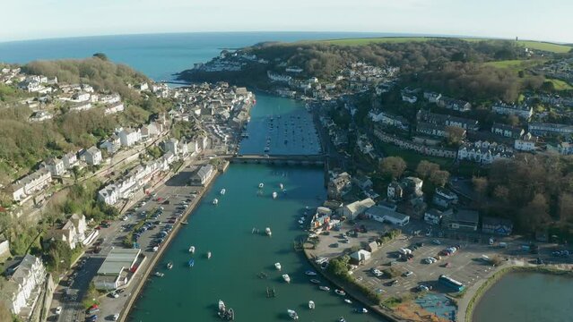 Aerial view of Looe, a small town with the harbour along the coastline in a small bay in Cornwall, United Kingdom.