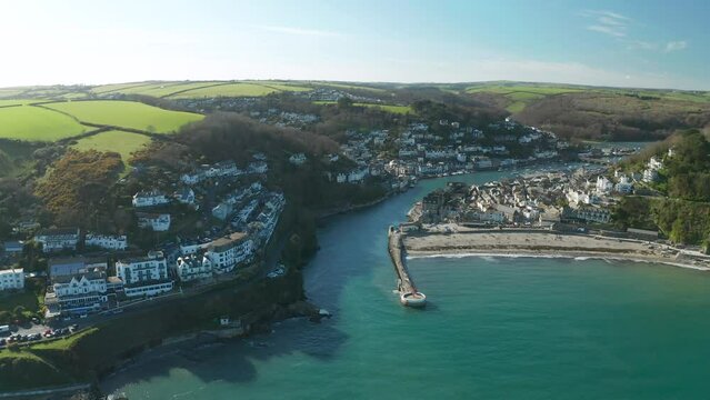 Aerial view of Looe, a small town with the harbour along the coastline in a small bay in Cornwall, United Kingdom.