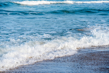 Sand beach, sea and cloudy blue sky at sunset